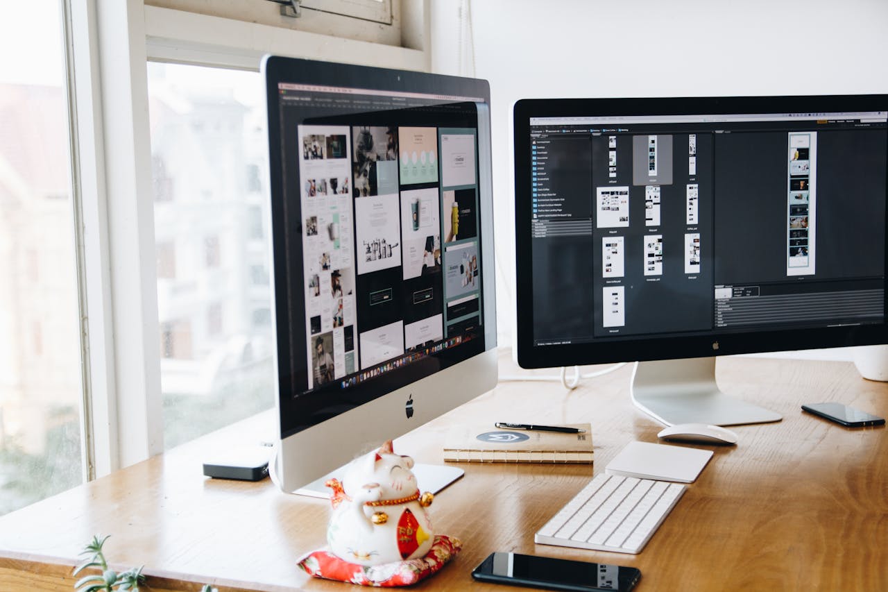 service-01 A sleek modern office setup featuring dual monitors, Apple devices, and creative decor in an indoor workspace.