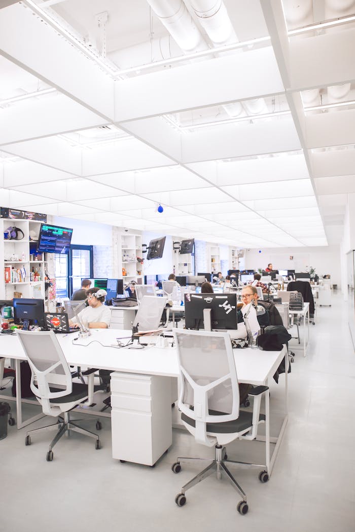 our-mission Bright modern office with employees working at desks, featuring a contemporary and open design.