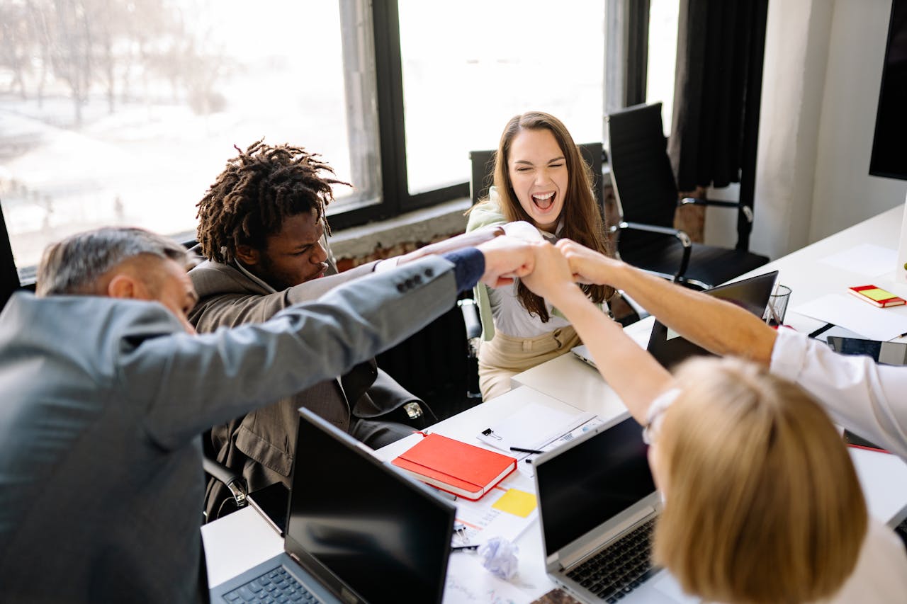 service-04 A diverse group of professionals celebrate a successful meeting with a fist bump.